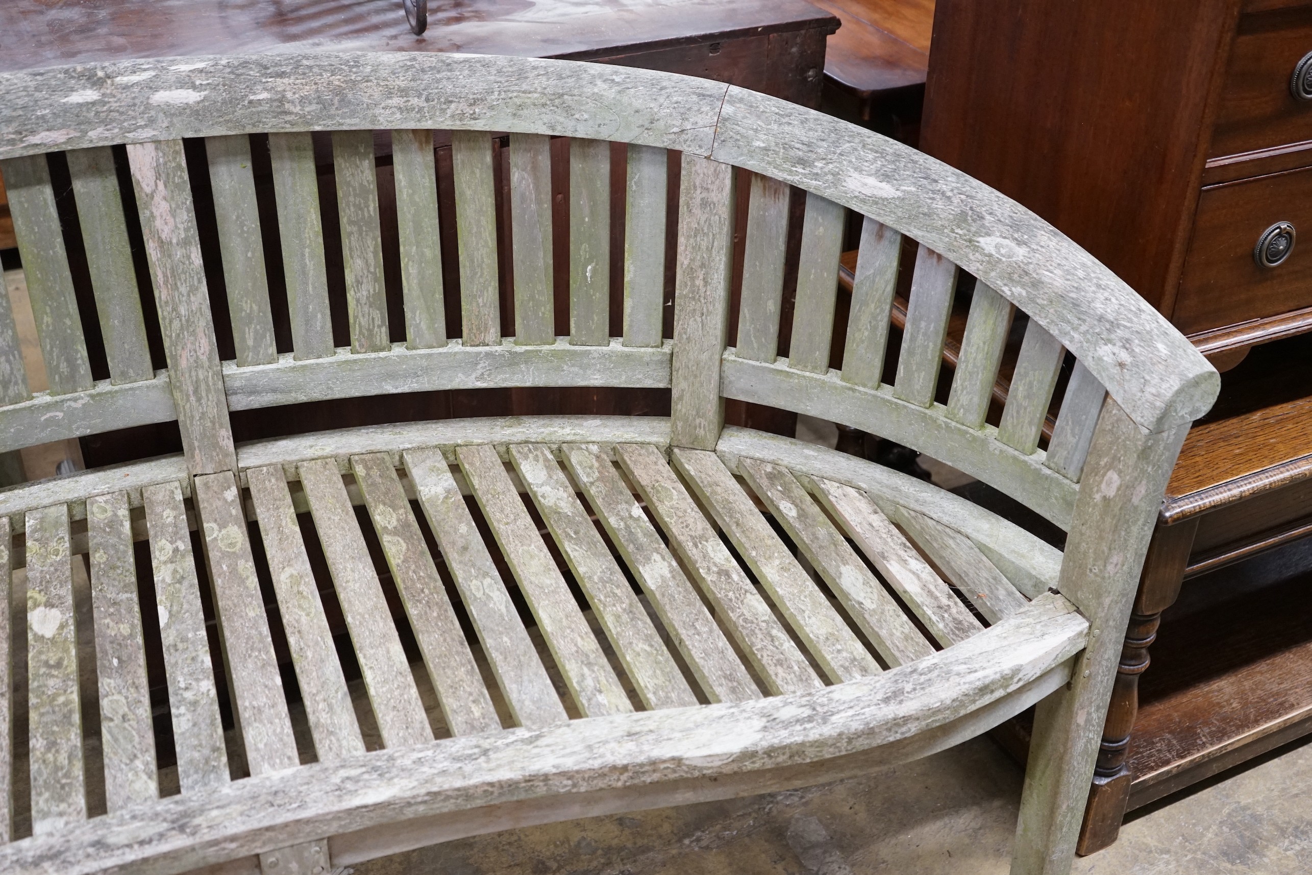 A weathered teak garden banana bench, length 160cm, depth 50cm, height 85cm